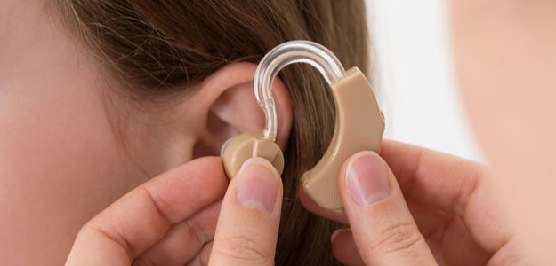 behind the ear hearing aid being fitted on a young girl