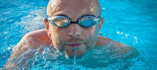 Man swimming in a pool with goggles