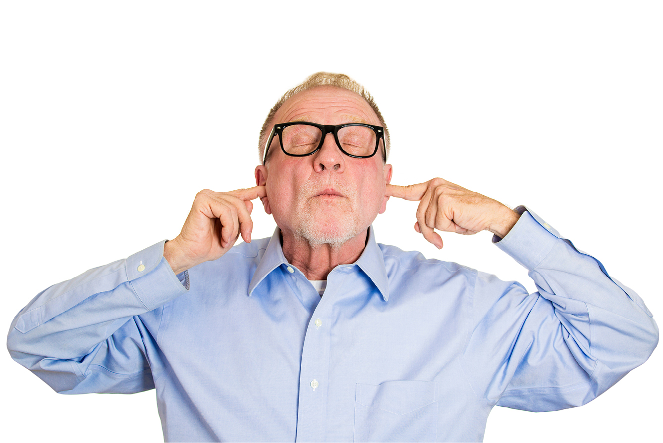 Middle aged man with glasses plugging his ears